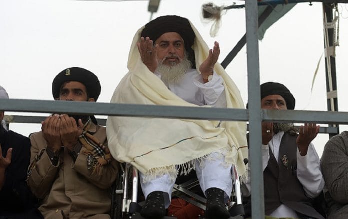 Head of the Tehreek-i-Labaik Yah Rasool Allah Pakistan (TLYRAP) religious group Khadim Hussain Rizvi (C), offers Friday prayers on a blocked flyover bridge