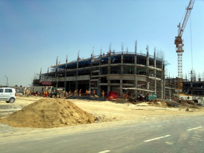 Pile of sand lying, building getting contructed. constructions contributes to major portion of air pollution in city