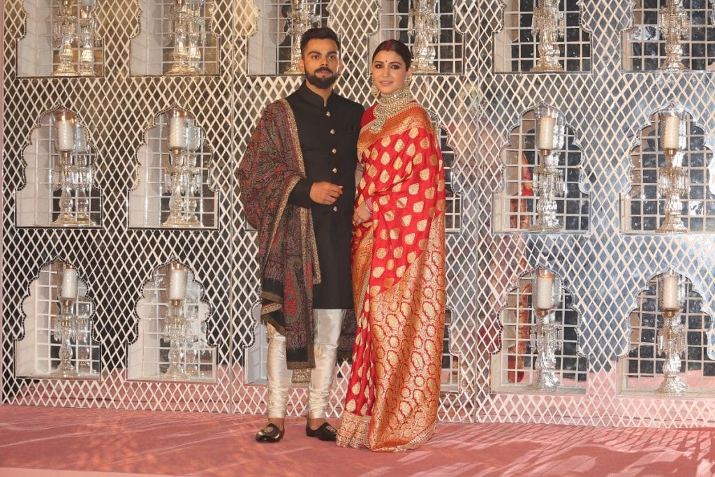 Anushka Sharma and Indian Cricket captain Virat Kohli pose for photographers during their reception