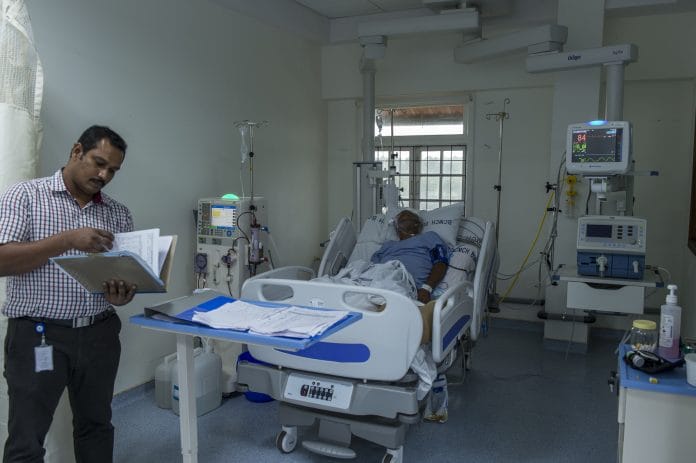 A hospital staff reviewing medical charts of a patient in a hospital
