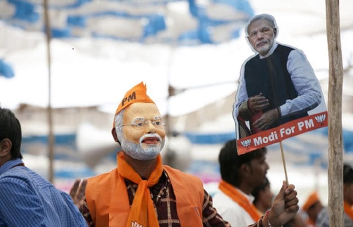 Man wearing a Narendra Modi mask at an election rally|