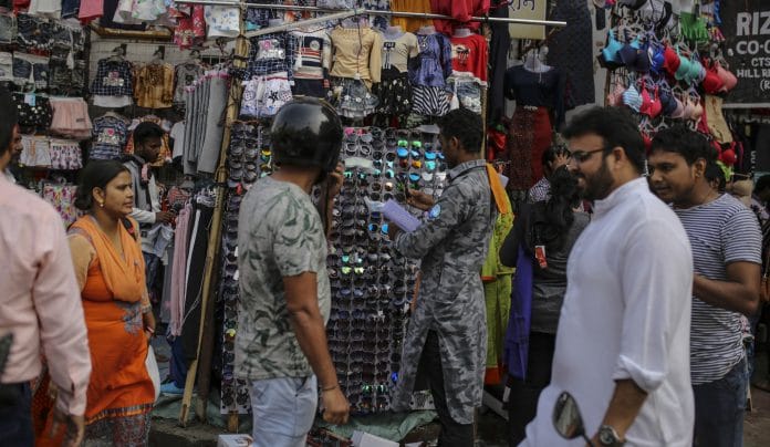 A shopper looks at sunglasses at a roadside stall in Mumbai, India.