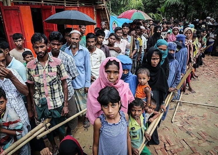 Refugees standing in a queue at a refugee camp