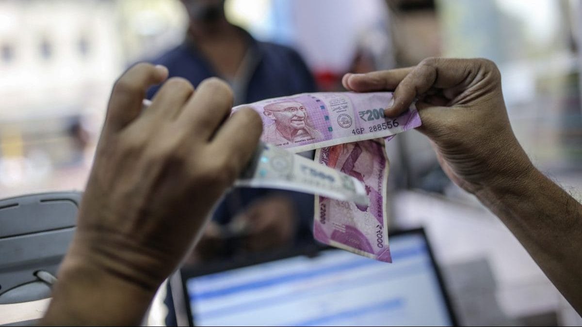 A cashier examines Indian rupee banknotes at the Mayuresh Watches and Traders watch and mobile phone store in the Byculla area of Mumbai