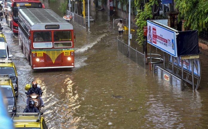 Buses wade through a water-logged street after heavy rains, in Mumbai