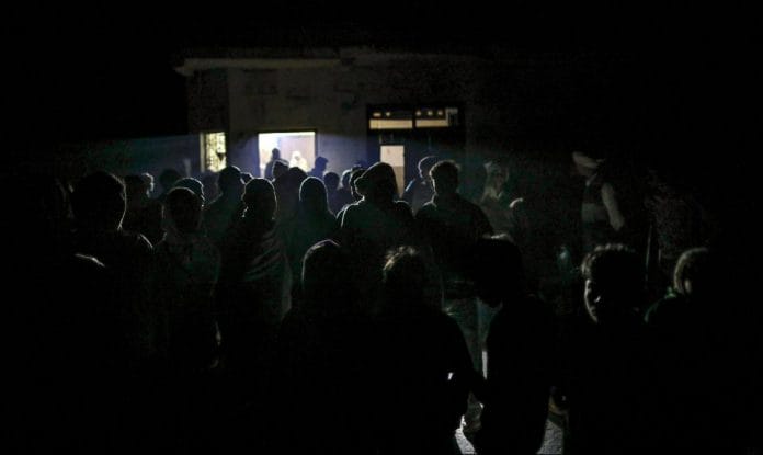 People gather outside a dairy shop in Fateh Nagla, Uttar Pradesh | Prashanth Vishwanathan/Bloomberg