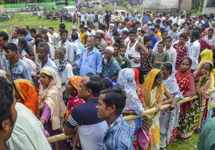 People wait to check their names on the final draft of the state's