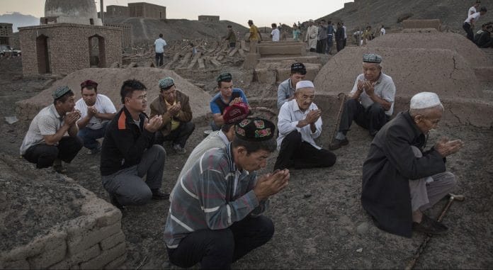 Uyghur men perform prayers in Xinjiang province, China | Kevin Frayer/Getty Images