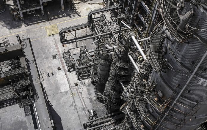 Employees walk through a refinery complex near Vadinar, Gujarat, India.
