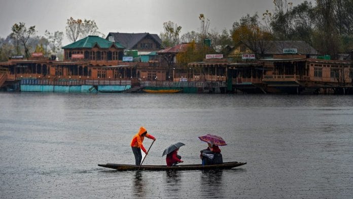 A young boy rows a boat carrying school children in Srinagar