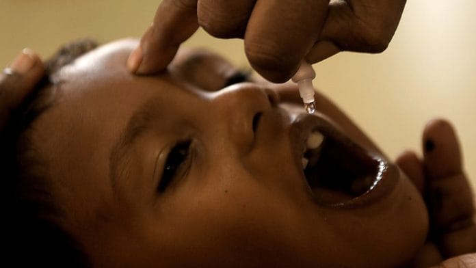 A child receives polio vaccine drops at a goverment hospital