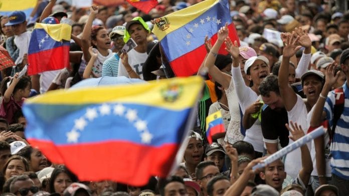 Attendees wave flags and cheer during the closing campaign rally for Evangelical pastor Javier Bertucci | Manaure Quintero/Bloomberg