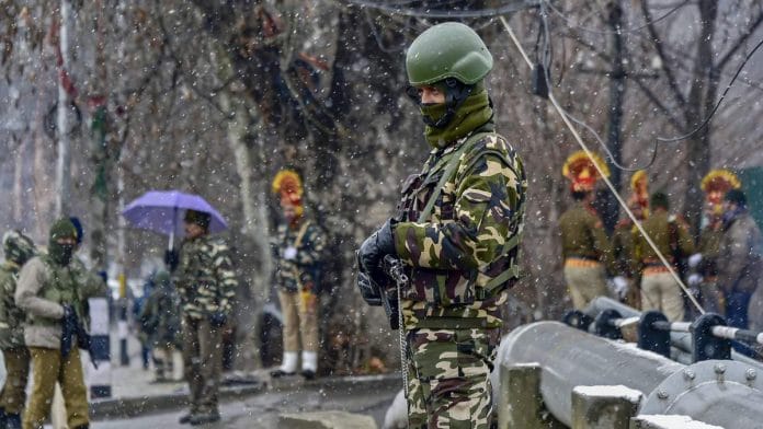 Security personnel stand guard amidst mild snowfall during full dress rehearsal for Republic Day function at Sher-e-Kashmir Cricket Stadium, in Srinagar