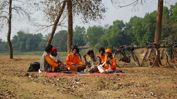 File image of the Bauls of Bengal. They sit in a group, dressed in saffron clothes.