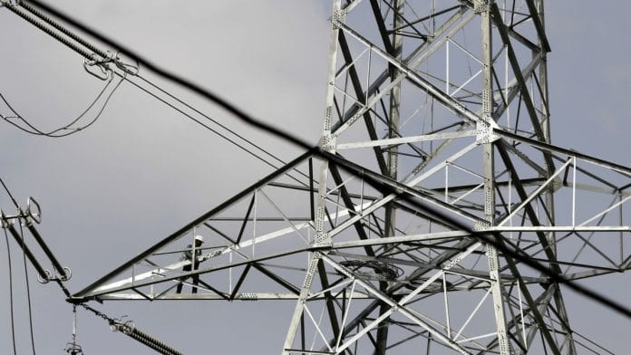 A technician works on a transmission tower in Rajouri district, Jammu and Kashmir | Dhiraj Singh/Bloomberg