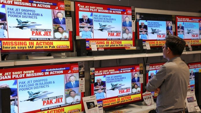 A man watches a television news report in New Delhi|T. Narayan/Bloomberg