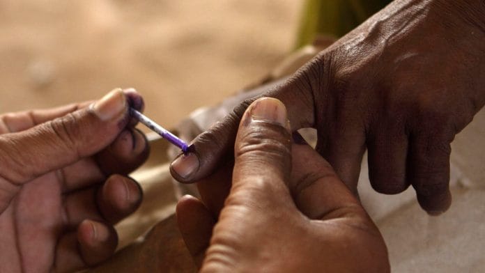 File photo of a woman casting her vote at a polling station in Varanasi | Pankaj Nangia/ Bloomberg News