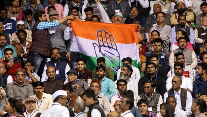 Attendees hold a Congress banner during an event in New Delhi | T. Narayan/Bloomberg
