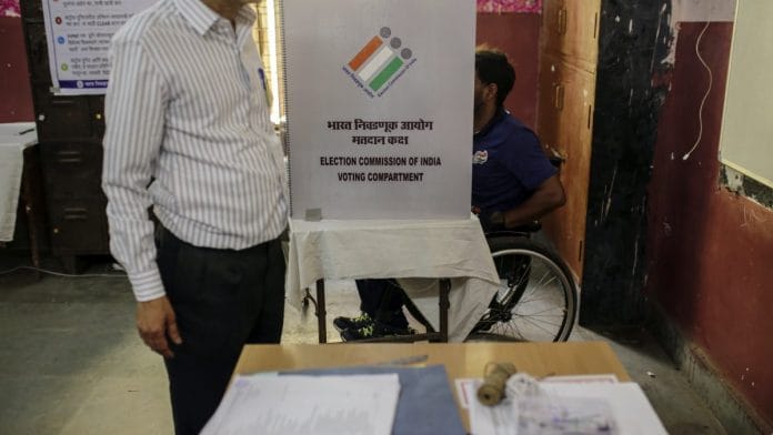 A voter in a wheelchair casts his ballot at a polling station in Mumbai | Dhiraj Singh/Bloomberg