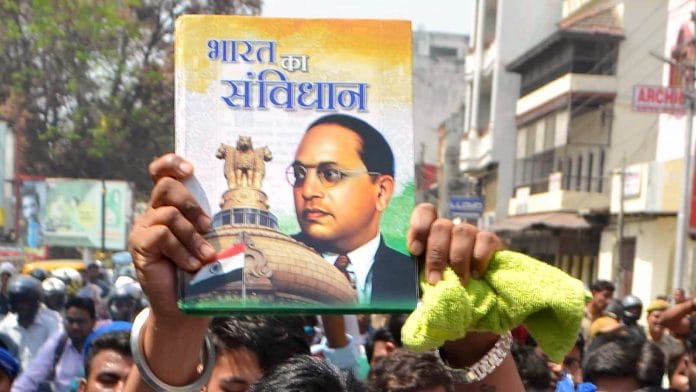 Representational image | Dalit leader Chandrashekhar Azad holds up a copy of the Constitution during a road show in Varanasi | ANI Photo