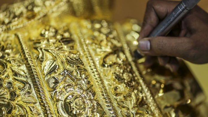 An employee works on a six kg gold crown for an up coming festival | Photographer: Dhiraj Singh | Bloomberg