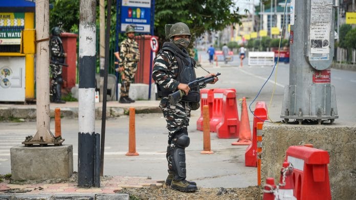 Security personnel stand guard during restrictions in Srinagar