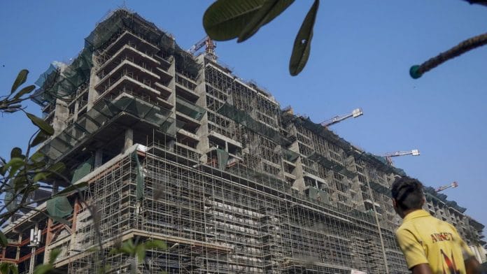a man walks past construction site of Reliance Industires at BKC (Bandra Kurla Complex) in Mumbai | Photographer: Dhiraj Singh | Bloomberg