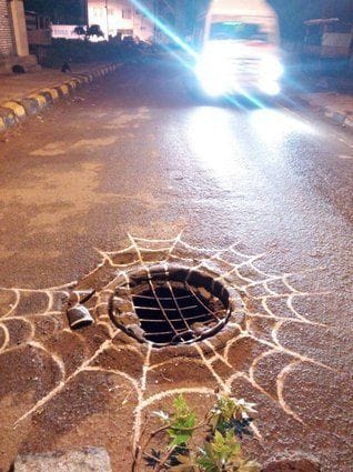 An uncovered manhole in the middle of the road, turned into a spider's web. | @royalbaadal | Facebook