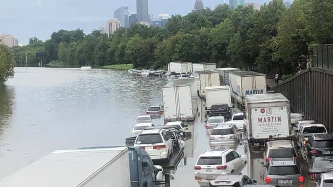 Vehicles on a flooded in Houston | Twitter: @ArtAcevedo