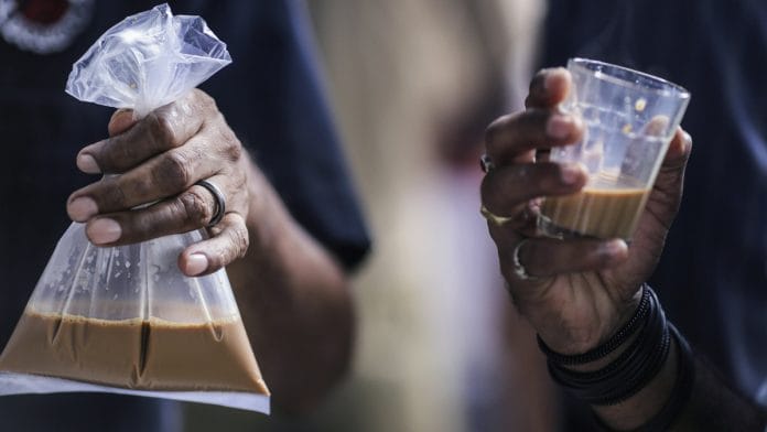 A customer holds a plastic bag containing chai | Dhiraj Singh/Bloomberg