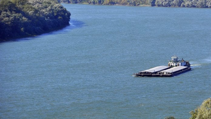 A vessel transports commercial barges along the Danube river near Pancevo, Serbia | Photographer: Oliver Bunic | Bloomberg