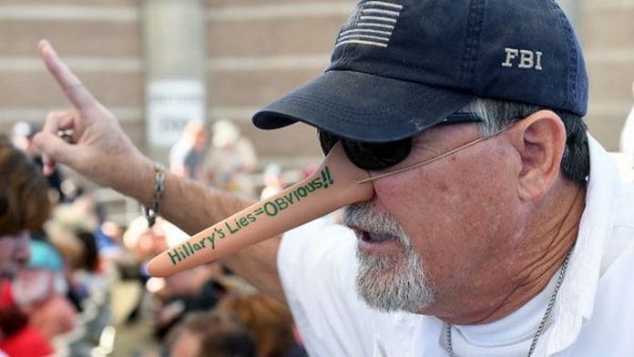 Mark James of Nevada, a supporter of Republican presidential nominee Donald Trump, wears a Pinocchio-themed nose during a campaign rally at the Henderson Pavilion | Photo by Ethan Miller | Getty Images/Bloomberg