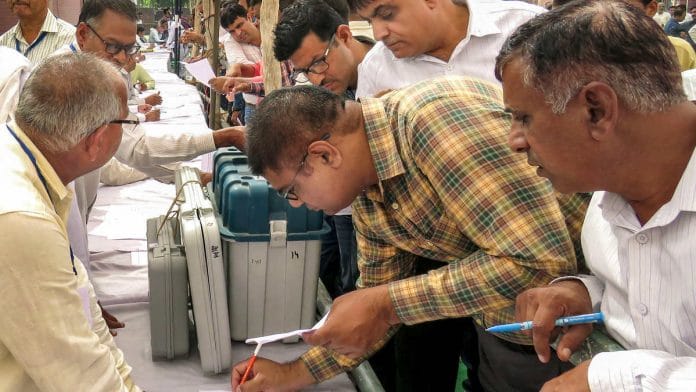 Polls officials collect EVMs and other materials at a distribution centre in Hisar on the eve of Haryana assembly elections. | Photo: PTI