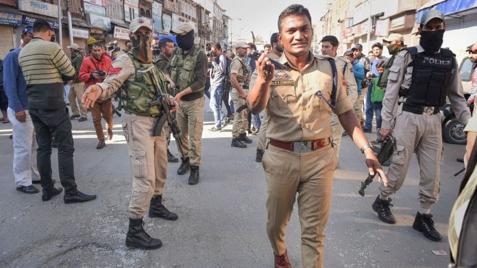 Police personnel inspect the site of the blast after a grenade was allegedly hurled by suspected militants