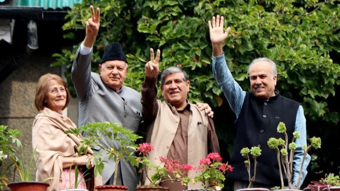National Conference President Farooq Abdullah, his wife Molly Abdullah, party leaders Mohammad Akbar Lone and Hasnain Masoodi wave towards media persons at their residence in Gupkar, Srinagar. | PTI