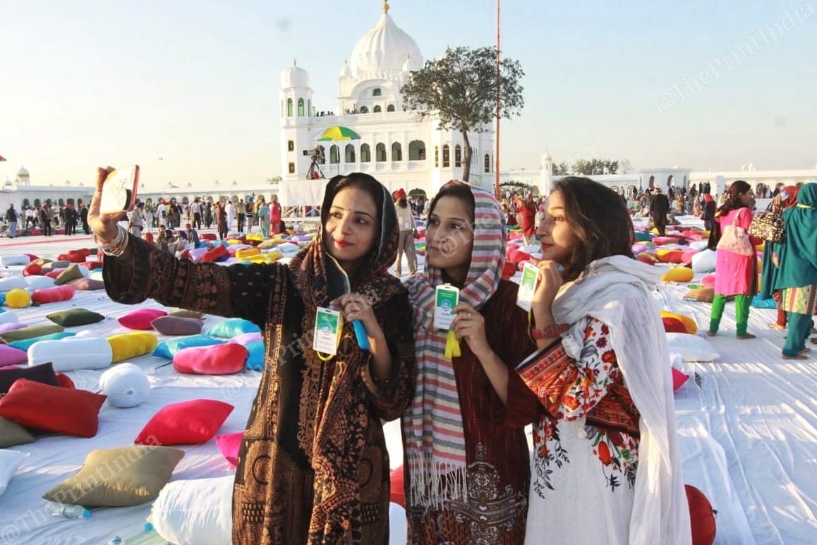 People at Gurdwara Darbar Sahib in Pakistan, taking a photo with their ID cards | Photo: Praveen Jain | ThePrint