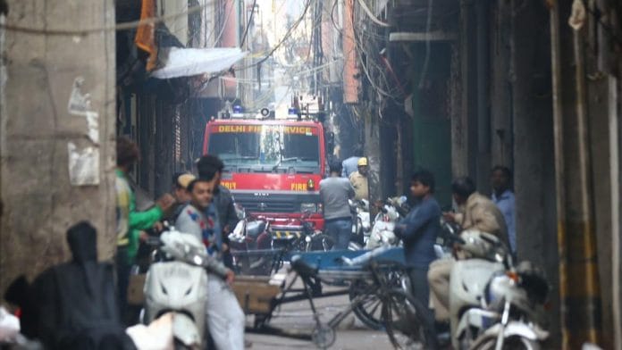 A fire bridge makes its way through a narrow lane towards the spot where fire broke out in New Delhi
