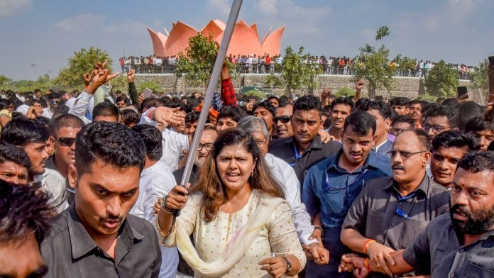 Senior BJP leader Pankaja Munde holds a police baton during her rally in Parli, Maharashtra