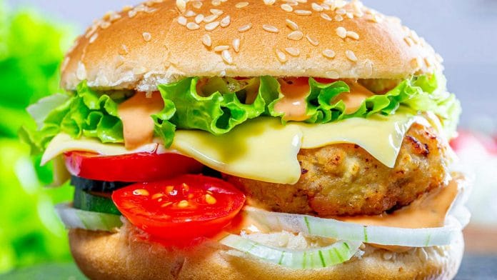 A burger with cheese, chicken