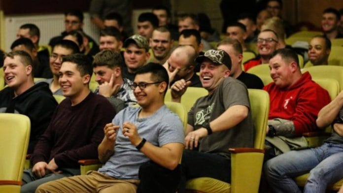 Audience laughing at jokes at an event | Wikipedia