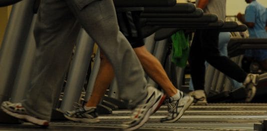 People running on a treadmill at a gym.
