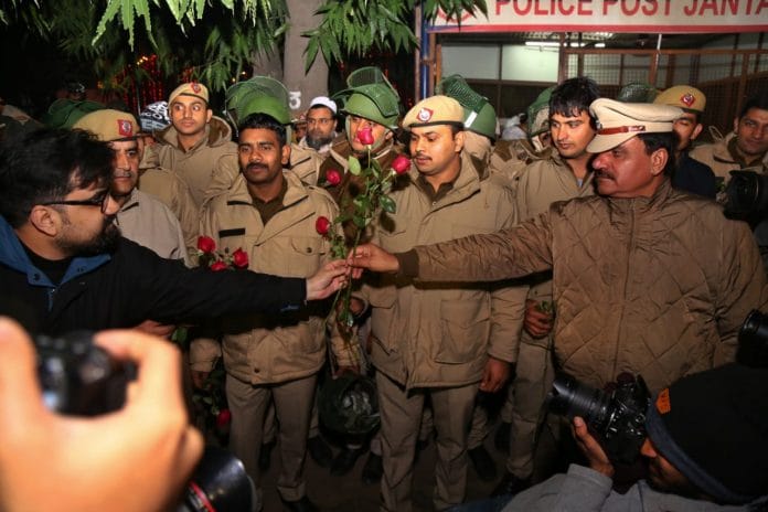 A protester hands a policeman a rose during an anti-CAA protest in Delhi. | Photo: Suraj Singh Bisht | ThePrint