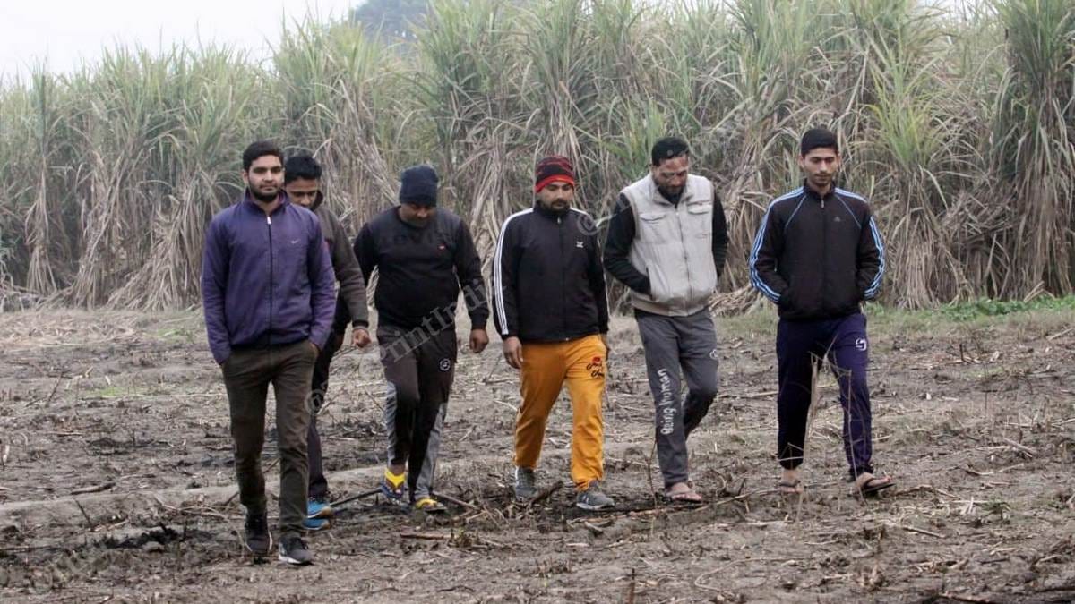Himanshu Sharma (extreme left in purple jacket) with his friends in a field in Jatpura village | Photo: Praveen Jain | ThePrint