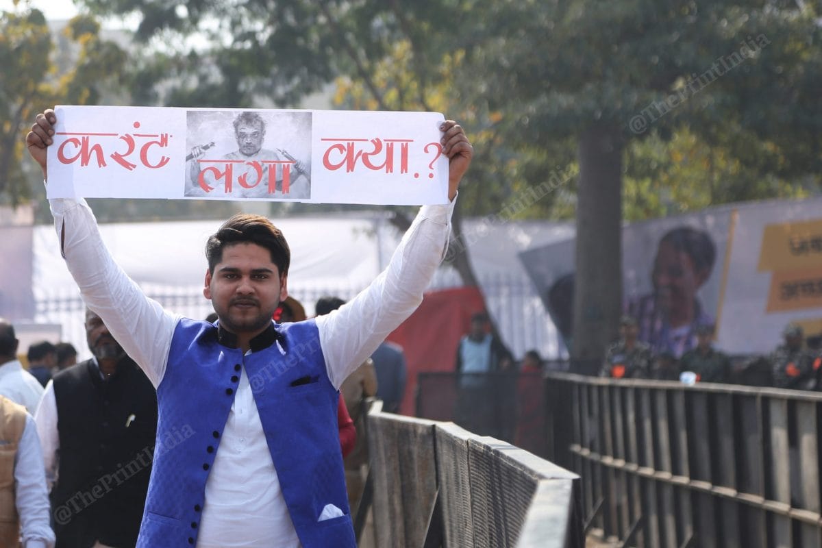 An AAP supporter holds a poster taking a dig at Home Minister Amit Shah | Photo: Manisha Mondal | ThePrint