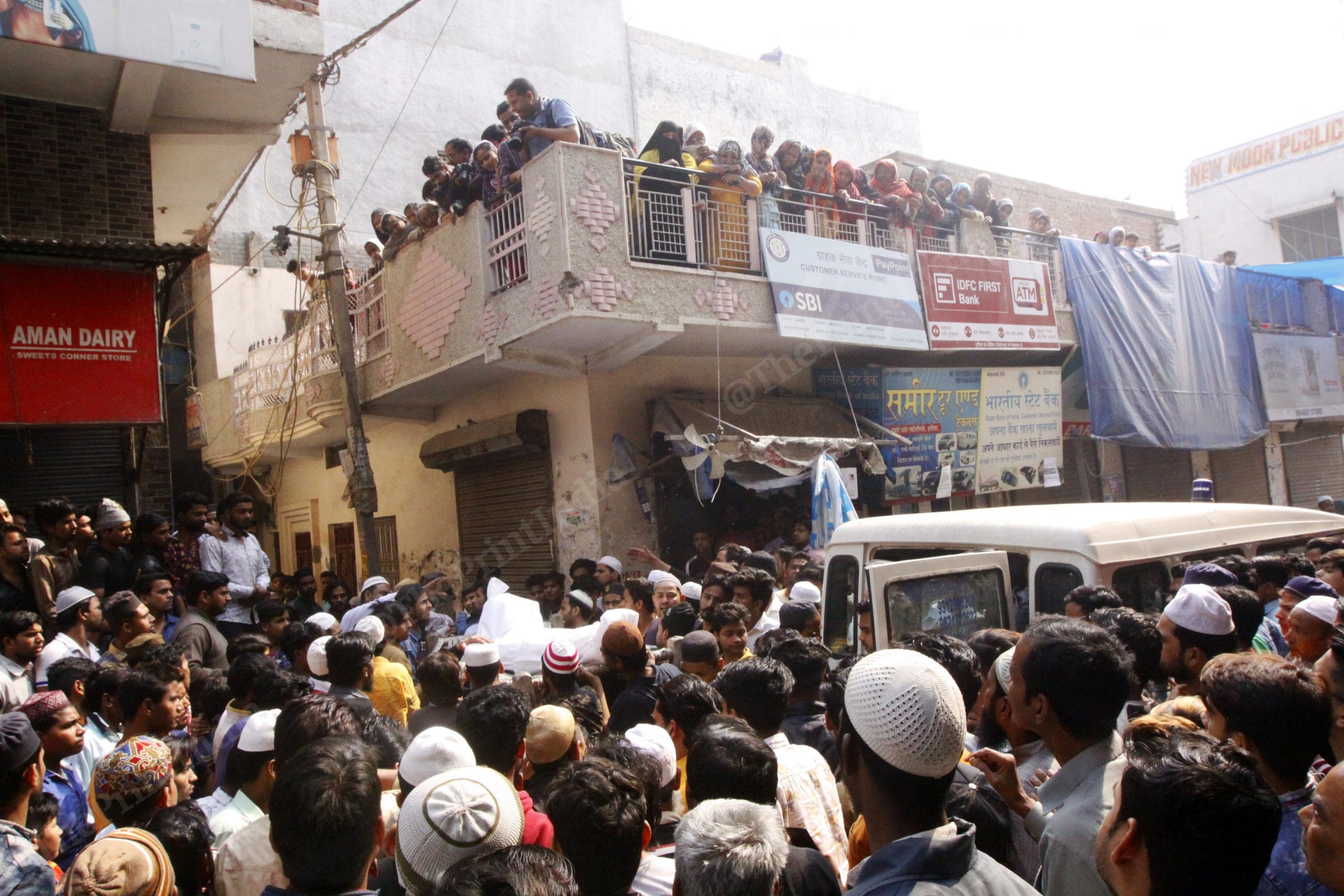 As the bodies reach their residence, hundreds gather to take them out from the van. Bodies being escorted to their residence inside a narrow bylane | Photo: Praveen Jain | ThePrint
