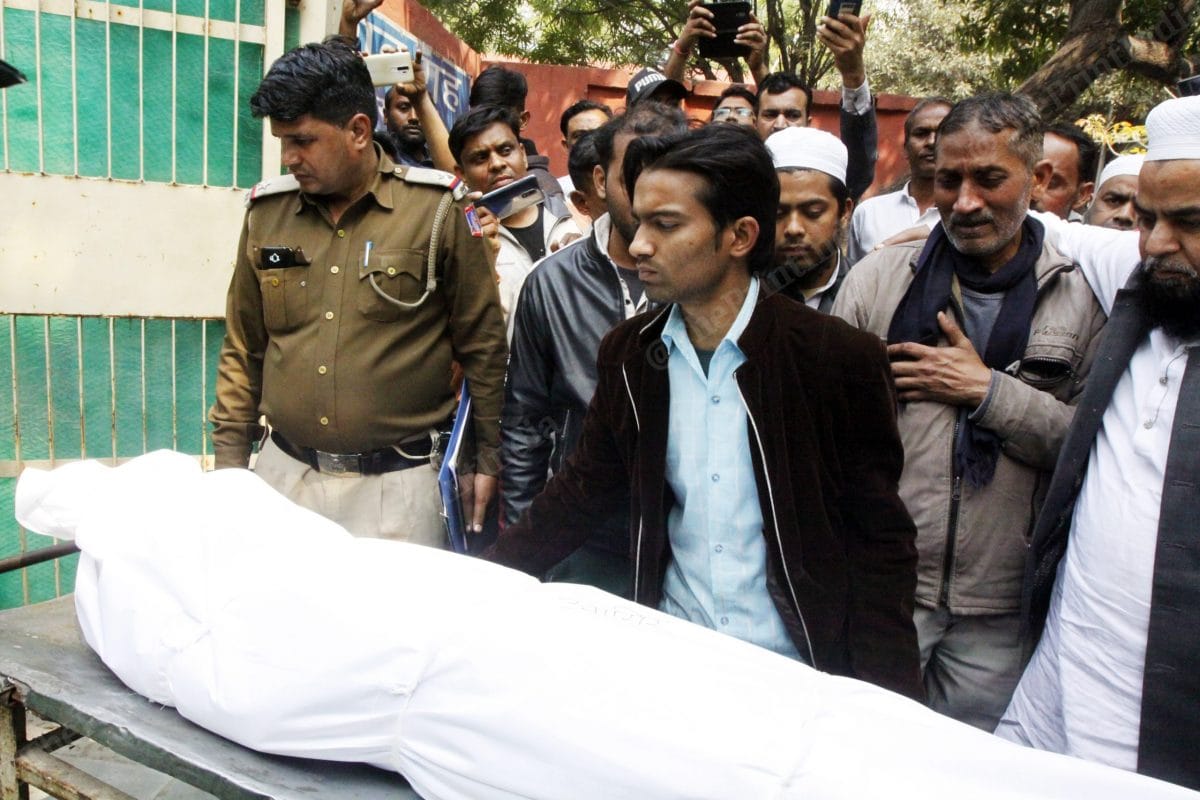 Babu Khan watches on as people put bodies of both his sons, covered in a white cloth, inside the van | Photo: Praveen Jain | ThePrint