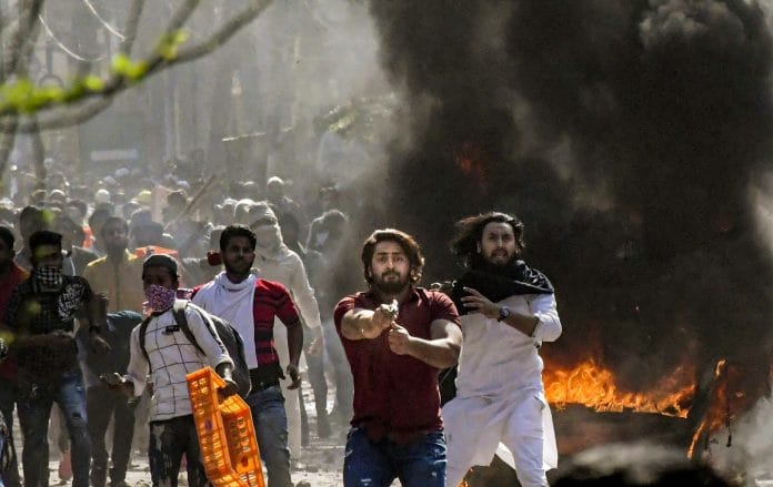 A protestor brandishes a pistol during clashes between a group of anti-CAA protestors and supporters of the new citizenship act, at Jafrabad in north-east Delhi | PTI