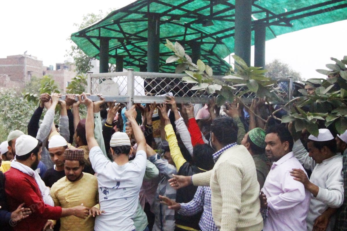 People help lay the bodies in the cemetery | Photo: Praveen Jain | ThePrint