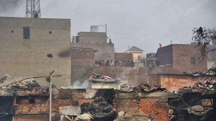 People stand on a terrace overlooking Gokulpuri where protests turned violent | Manisha Mondal | ThePrint