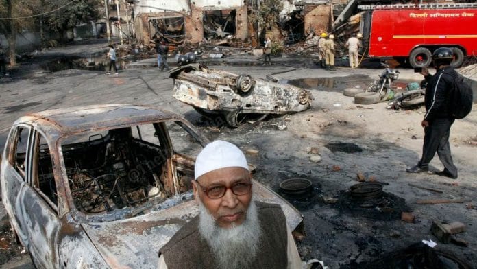 A man stands amid the burnt-out ruins of the Gokulpuri tyre market in Northeast Delhi | Photo: Praveen Jain | ThePrint